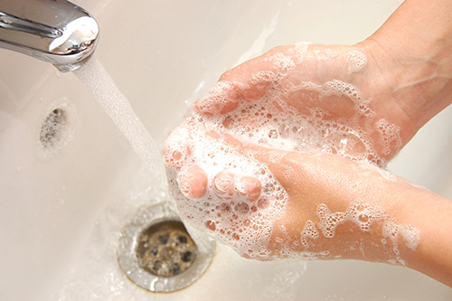 woman washing hand under running
